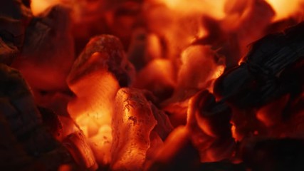 Closeup slow motion shot of fire sparks moving on dark at black background coming from brightly burning warm