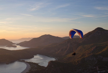 Paraglider flying at sunset over Blue lagoon in Oludeniz, Turkey