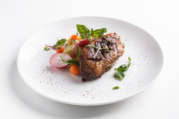 Roast duck breast with vegetables. Served on a white plate