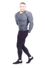 Portrait of young confident bodybuilder or gym instructor posing on white background