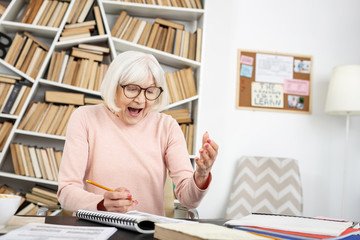 Unexpected solution. Jovial mature woman shouting while doing task