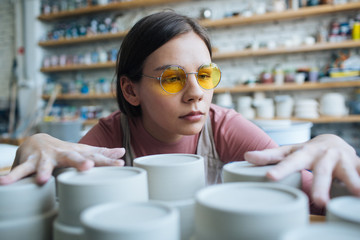 Handcrafted on a potter's wheel,Hands make clay from various items for home and sale in the store and at the exhibition, ceramic items are made in hand, beautiful girl makes products from clay