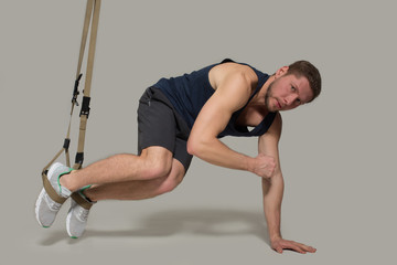 Obraz premium Young man training at gym in vertical position. Looking at camera. Sport concept.