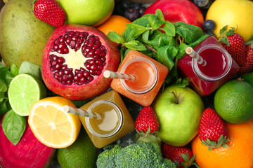 Bottles with healthy detox smoothies and ingredients as background