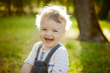curly toddler smiling, laughing for a walk in the park, large portrait.