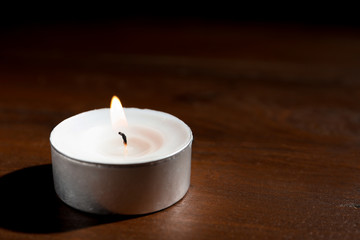 Obraz na płótnie Canvas Wax candle burning on wooden table