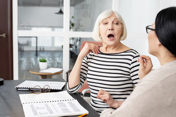 Mind your lips. Appealing senior tutor and student opening mouth and practicing