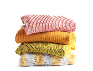 Fototapeta na wymiar Stack of warm knitted clothes on white background