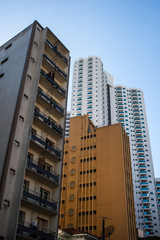 Fototapeta na wymiar Aged residential buildings near a white new tall tower