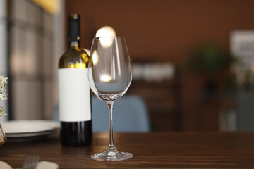 Glass and bottle of wine on table in restaurant