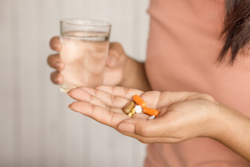 woman hand taking pill and glass of water in hand ,healthcare and medical concept