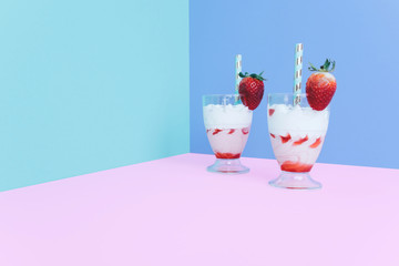 Milkshake with straw and strawberry.