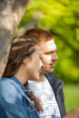 Fototapeta premium Young couple having fun, talking, flirting in a sunny park in springtime, beautiful, romantic mood