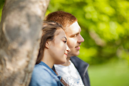Young couple having fun, talking, flirting in a sunny park in springtime, beautiful, romantic mood