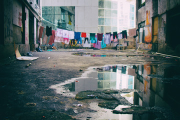 Colourful clothes hanged to dry among a humid decayed complex of residential buildings.