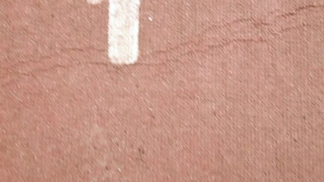 Starting line and number one position lane on athletic racetrack, high angle view tracking shot close up