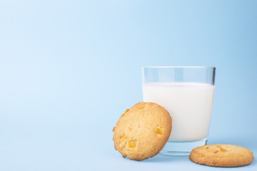glass of milk and cookies on a blue background