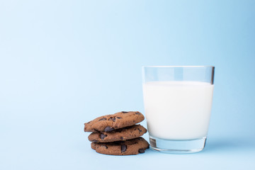 glass of milk and a school chocolate biscuit on a blue background