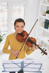 Be delightful. Joyful young female keeping smile on her face while demonstrating her skills