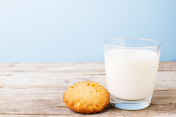 cookies and a glass of milk on a light table, on a blue background