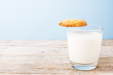 cookies and a glass of milk on a light table, on a blue background