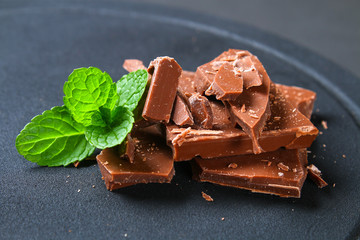 Chocolate on dark stone background. Top view with copy space.