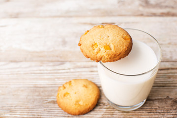  cookies and a glass of milk on an old board, top view