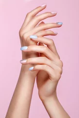 Fotobehang Mooie roze en blauwe manicure met kristallen aan de vrouwelijke kant. Detailopname. Foto genomen in de studio © Kobrinphoto