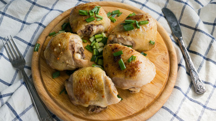 Delicious roast Chicken with green onion and spices on the wooden plate