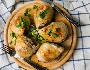Delicious roast Chicken with green onion and spices on the wooden plate