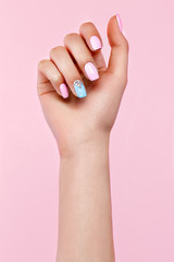 Belle manucure rose et bleue avec des cristaux sur la main féminine. Fermer. Photo prise en studio