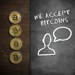 Bitcoin Münzen auf Holzuntergrund mit Wandtafel und Hinweis 