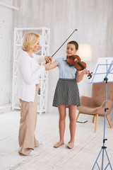 Repeat after me. Serious blonde woman standing in semi position while holding bow