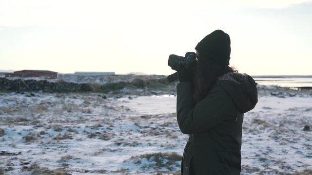 Travel girl takes a photo of winter Iceland.