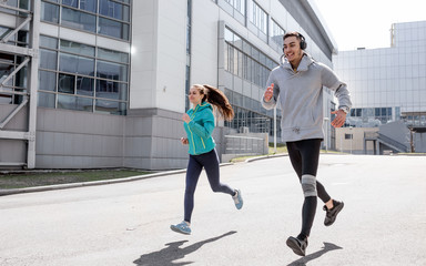 Young people go in for sports in the city. Running in the city. Friends are running around town