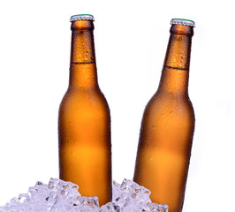 Bottle of beer with drops and ice isolated on white background