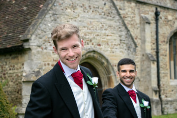 Gay wedding, grooms leave village church after being married with big smiles and holding hands