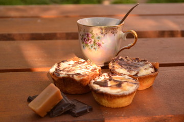 Sweet chocolate cakes, chocolate and caramels a cup of coffee on wooden table