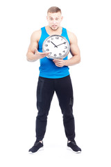Full-length portrait of fit athlete holding wall clock on white background