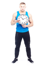 Full-length portrait of fit athlete holding wall clock on white background