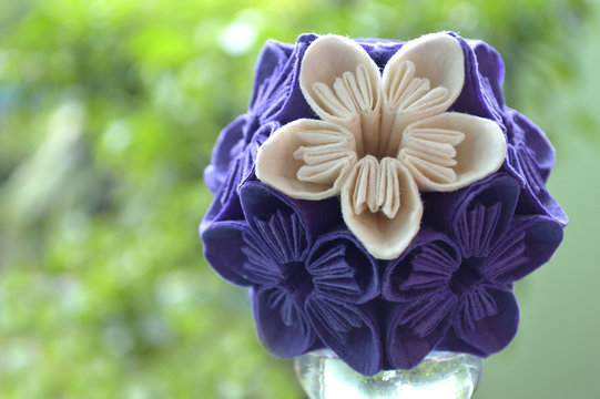 Purple and white origami kusudama flower on natural background