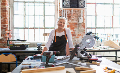 Senior woman doing woodwork in a workshop
