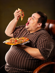 Diet failure of fat man eating fast food slice pizza on plate. Close up of breakfast for hungry overweight person who spoiled healthy food. He can not refuse harmful food.