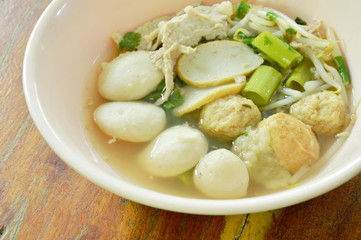 boiled fish and shrimp ball topping slice pork in clear soup on bowl