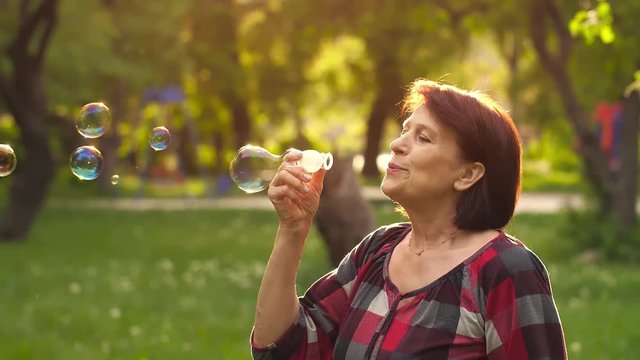 Mature woman blowing bubbles