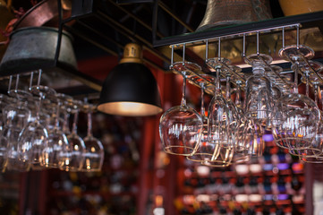 Clean washed glasses hanging over a bar rack