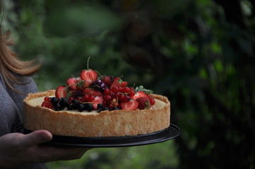 In a green garden in the nature fruit pie with strawberries and other berries