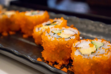 California maki sushi roll on black plate, japanese food