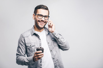 Portrait of happy young man talking on phone and drinking tea. Isolated white background.