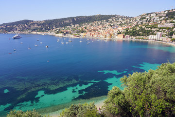 Fototapeta na wymiar Panoramic view of the harbor town of Villefranche sur Mer, a coastal resort city on the Mediterranean Sea on the French Riviera seen from the Corniche